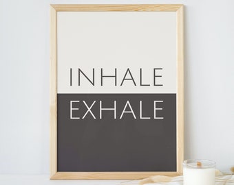 Könnte beinhalten: Ein gerahmter Druck mit den Worten "INHALE EXHALE" in Schwarzweiß auf weißem und schwarzem Hintergrund. Der Druck liegt auf einer weißen Oberfläche mit einer Kerze und getrockneten Blumen.