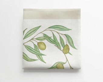 May include: A white linen tea towel with a watercolour illustration of olive branches and green olives.