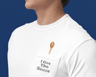 May include: White t-shirt with a pocket featuring a wooden spoon and the text "I Got The Sauce".