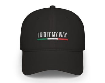 May include: Black baseball cap featuring the text "I DID IT MY WAY." above a horizontal stripe in the colours of the Italian flag: green, white, and red. The cap has a curved peak and a structured crown.