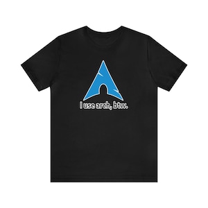 Puede incluir: Camiseta negra con un logotipo azul de Arch Linux y el texto "Uso arch, por cierto."