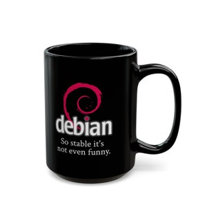May include: Black ceramic mug with a white "debian" logo and a pink Debian logo. The text below the logo reads "So stable it's not even funny."