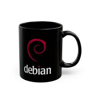May include: Black ceramic mug with a red spiral logo and the word "debian" in white. The mug has a curved handle and a glossy finish. A simple, yet bold design for tea or coffee.