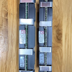May include: Two black Kingston KTA-MP800K2/20 1GB 2RXB PC2-6400 RAM modules with silver clips. The modules have a black label with white text and a red Kingston logo.