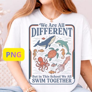 Peut inclure: T-shirt blanc avec un motif marin coloré. Il présente une baleine, un dauphin et d'autres créatures marines, ainsi que le texte "We Are All Different But in This School We All Swim Together."