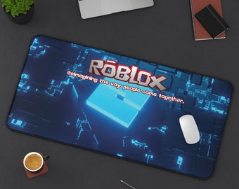 May include: A rectangular desk mat featuring a dark blue digital circuit board pattern with a central glowing light blue square. The Roblox logo is printed in the center with the text, "Reimagining the way people come together."