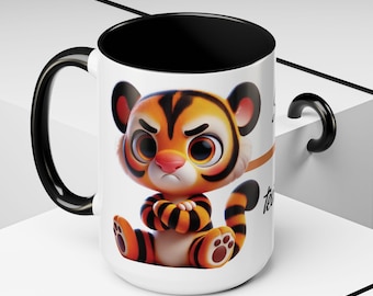 May include: A white ceramic mug with a black interior and handle, featuring a graphic of a cartoon tiger with orange and black stripes, large eyes, and crossed arms. The tiger has a grumpy expression and is sitting in a seated position.