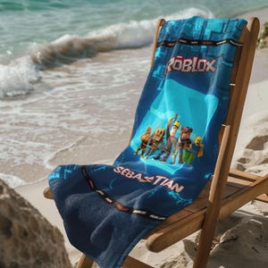 May include: A blue beach towel with a Roblox logo and a group of cartoon characters. The towel has the name "Sebastian" printed on it.