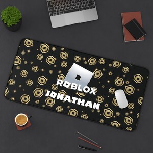 May include: Black rectangular mousepad with a gold coin pattern and the Roblox logo. The name "Jonathan" is printed below the logo in white. A white mouse sits on the right side of the pad.