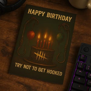 Könnte beinhalten: Geburtstagskarte mit dem Text "Happy Birthday" und "Try Not to Get Hooked". Die Karte zeigt einen Kuchen mit Kerzen, Luftballons und Haken. Eine Tasse Kaffee und eine Tastatur sind ebenfalls sichtbar.