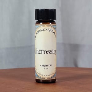 May include: A small brown glass bottle with a black lid and a label that reads "Crooked Stick Apothecary" and "Uncrossing Conjure Oil .5 oz".
