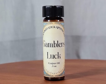May include: A small brown glass bottle with a black cap and a label that reads "Crooked Stick Apothecary Gamblers Luck Conjure Oil .5 oz".