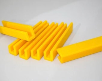 Puede incluir: Un conjunto de ocho soportes en forma de U de plástico amarillo brillante. Los soportes miden aproximadamente 7,5 cm de largo y 2,5 cm de ancho.