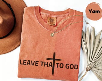 May include: A coral colored t-shirt with a black cross and the text "LEAVE THAT TO GOD".