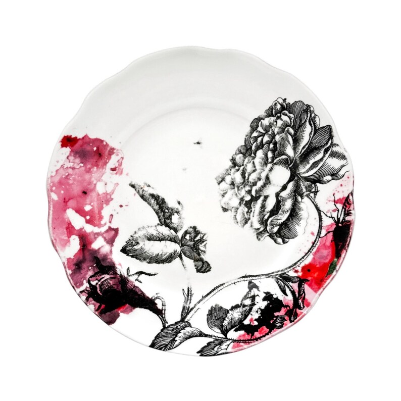 K&ouml;nnte beinhalten: Wei&szlig;er Keramikteller mit gewelltem Rand. Der Teller hat ein schwarz-wei&szlig;es Blumendesign mit einer gro&szlig;en Pfingstrose und kleineren Bl&uuml;ten. Rote und rosa Aquarell-Akzente setzen Farbakzente.