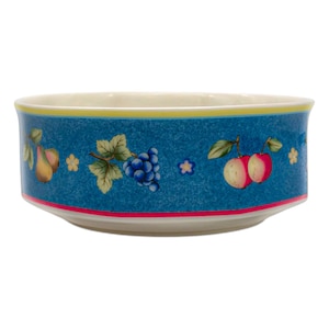 May include: A ceramic bowl with a blue exterior featuring a fruit design. The bowl has a yellow and pink trim. The fruit illustrations include pears, grapes, and apples. The bowl is suitable for serving food.