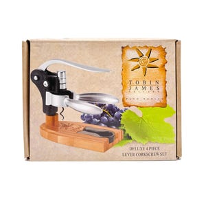 May include: A deluxe 4-piece lever corkscrew set in a cardboard box. The set includes a black and silver corkscrew with a wooden base, a foil cutter, and a bottle opener. The box features the text "TOBIN JAMES CELLARS" and a sun illustration.