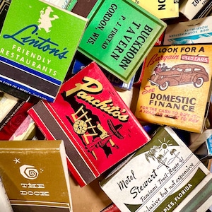 May include: A collection of vintage matchbooks with various designs and text. The matchbooks feature logos and names of restaurants, motels, and businesses. Colors include green, red, yellow, and brown. Some matchbooks have text like "Linton's Friendly Restaurants" and "Motel Stewart".