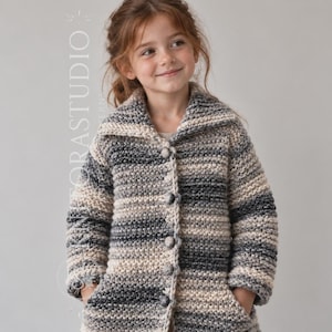 May include: A long-sleeved, chunky knit cardigan featuring a variegated colour palette of grey, charcoal, and cream tones. The garment has a wide collar, a button-down front with five round buttons, and two front pockets. Text reads FLORA STUDIO.