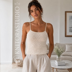 Könnte beinhalten: Ein ärmelloses Strick-Top in Cremefarben mit dünnen Spaghettiträgern und einer gerippten Textur. Das Kleidungsstück hat einen geraden Ausschnitt und eine körpernahe Passform. Der Text KNITORASTUDIO KNITTING PATTERNS ist links zu sehen.