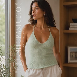 Könnte beinhalten: Ein helles, salbeigrünes Strick-Neckholder-Top mit tiefem V-Ausschnitt, dünnen Trägern und gerippter Textur. Das ärmellose Kleidungsstück hat einen geraden Saum. Der Text KNITORASTUDIO KNITTING PATTERNS ist vertikal auf der linken Seite zu sehen.