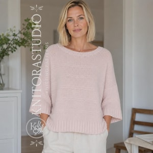 Pode incluir: Uma camisola de malha rosa pálido com um decote barco largo, mangas três quartos com punhos canelados e uma bainha canelada a condizer. A peça apresenta um padrão subtil de riscas horizontais texturizadas no corpo e nas mangas.