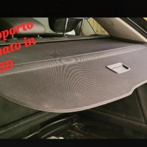 May include: A black car cargo cover with a handle and a mesh-like texture. The text in the image reads "con supporto stampato in 3D".
