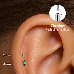 Puede incluir: Primer plano de una oreja con dos pendientes de titanio sin rosca, rectangulares, de color verde esmeralda. Uno mide 3 mm, el otro 4 mm. La imagen también muestra un diagrama de montaje.