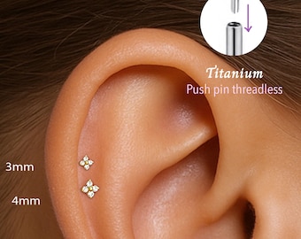 Könnte beinhalten: Nahaufnahme eines Ohrs mit zwei kleinen, klaren Edelstein-Blumen-Push-Pin-Ohrringen. Die Ohrringe sind 3 mm und 4 mm groß. Die Ohrringe sind aus Titan und sind ohne Gewinde.