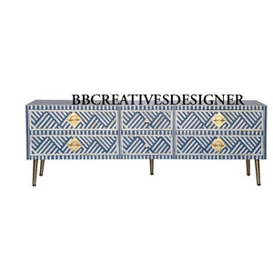 May include: A six-drawer dresser with a blue and white geometric pattern. The dresser has gold metal handles and sits on four gold metal legs.