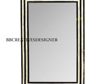 May include: A rectangular mirror with a black and white bone inlay frame. The frame has a triple border design.