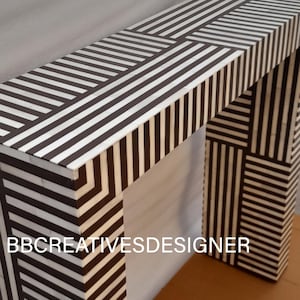 Könnte beinhalten: Ein schwarzer und weißer Konsolentisch aus Knocheninlay. Der Tisch hat ein geometrisches Muster und ist ein einzigartiges Möbelstück.