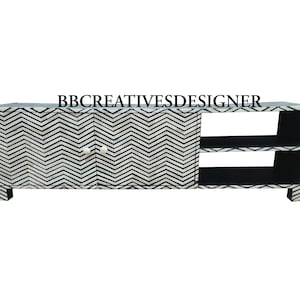 May include: A black and white chevron patterned bone inlay TV stand with two doors and two open shelves. The stand has a modern design and is perfect for any living room.