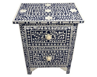 May include: A two-drawer bedside table with intricate floral bone inlay designs on a dark blue background. The drawers have white bone inlay knobs. The bedside table is made of wood and has a rectangular shape. The text "BBCREATIVESDESIGNER" is visible on the front of the bedside table.
