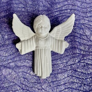 May include: White ceramic angel ornament with wings outstretched and a simple, flowing robe. The angel has a sweet, innocent expression on its face.