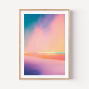 Peut inclure: Une impression d'art mural rectangulaire dans un cadre en bois clair représentant un paysage abstrait avec un dégradé de couleurs. La composition passe du bleu profond en haut aux teintes rose, pêche et orange, finissant sur une base violette.