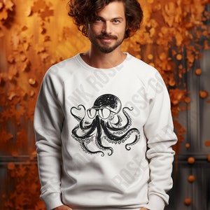 Puede incluir: Sudadera blanca con un estampado gr&aacute;fico de un pulpo negro con gafas de sol. El pulpo tiene un dise&ntilde;o de galaxia dentro de su cabeza.