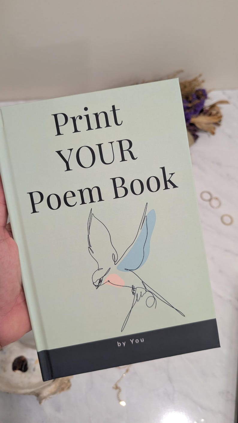 Pu&ograve; includere: Un libro verde chiaro intitolato "Print YOUR Poem Book" con un disegno a tratto di un uccello. Il libro ha una fascia nera in basso con la scritta "by You". L'uccello ha accenti blu e rosa.