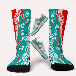 May include: A pair of teal and red socks with a white wave pattern and dollar signs, diamonds, and arrows. The socks are paired with teal and orange trainers.