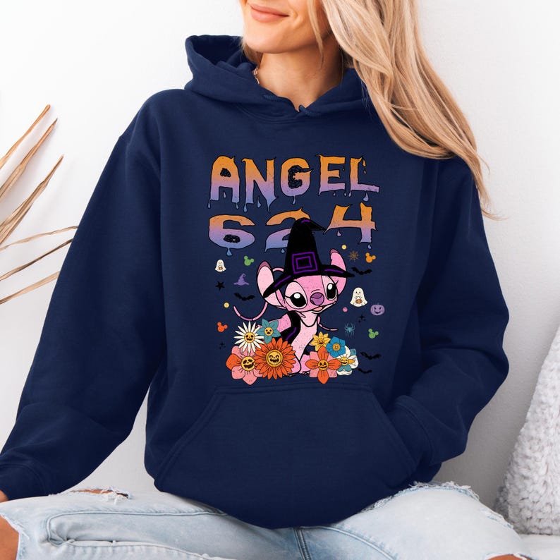 May include: Navy blue hooded sweatshirt featuring a graphic of a pink alien character wearing a witch hat, surrounded by flowers and the text "ANGEL 624". The design has orange, purple, and white accents, with Halloween-themed elements.