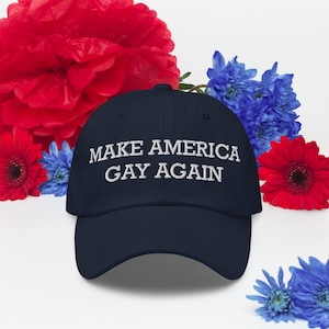 Könnte beinhalten: Eine marineblaue Baseballkappe mit dem gestickten Text "MAKE AMERICA GAY AGAIN" in Weiß. Die Kappe ist von roten und blauen Blumen umgeben.