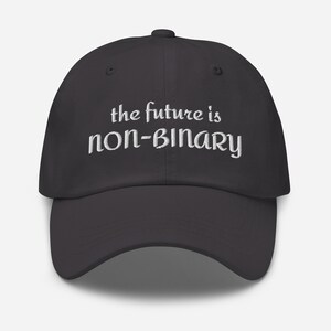 May include: A black baseball cap featuring white embroidered text on the front panel that reads the future is non-binary. The cap has a curved brim, a structured crown, and a button at the top center, providing a classic look and fit.