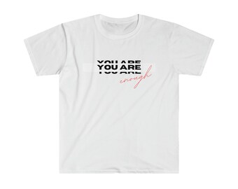 以下が含まれることがあります： 白地に黒と赤で「YOU ARE YOU ARE enough」と書かれたTシャツ