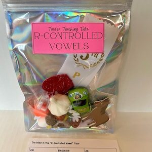 May include: A clear plastic bag filled with various learning materials for teaching R-controlled vowels. The bag includes a pink label that reads "Tusler Teaching Tubs R-CONTROLLED VOWELS". The bag also includes a list of words with different vowel sounds, such as "fork", "worm", "turtle", "giraffe", "car", and "marble".