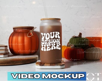 May include: A brown insulated tumbler with a bamboo lid and a white straw. The tumbler has the text "YOUR DESIGN HERE" in a retro font. The tumbler is sitting on a wooden coaster and there are fall-themed decorations in the background.