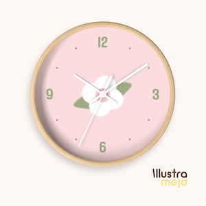 May include: A round wall clock with a light pink face and a light wood frame. The clock face features a white flower design, green leaves, and black numerals. The clock hands are white. The text "Illustra meja" is at the bottom right.