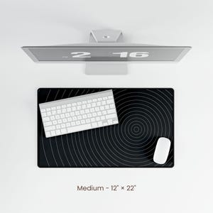 May include: A black and white circular pattern mouse pad with a white keyboard and white mouse on top. The mouse pad is 12 inches by 22 inches.