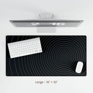May include: Black and white circular design desk mat with a white keyboard and white mouse. The mat is 16 inches by 32 inches.
