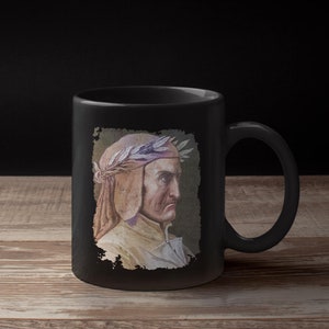 May include: Black ceramic mug with a white image of a man with a laurel wreath on his head. The man is wearing a brown and white robe. The image is surrounded by a distressed black border.
