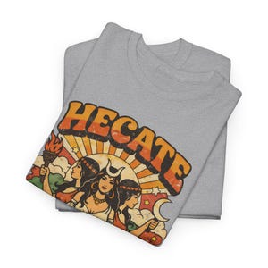 Vintage 70s Hecate retro shirt featuring the Triple Goddess in a mystical boho design, inspired by witchcraft, Wiccan and pagan spirituality. This witchy graphic tee shows Hekate with moon phases and occult symbols, perfect for spiritual women, witches, and lovers of magic. Ideal witchy gift for Wiccan, pagan and boho aesthetic fans.